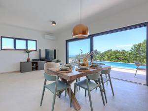 a dining room with a table and chairs and a large window at Villa Florinda by Interhome in Raša +54 photos