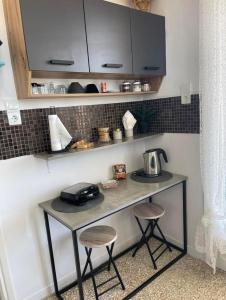 a small table with two stools in a kitchen at Maison De La Mer in Isthmia
