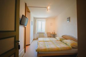 a hotel room with a bed with a tv on it at La Caquerelle in Col des Rangiers