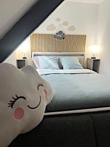 a bedroom with a bed with a stuffed animal at Le Nuage - Vidéoprojecteur - Terrasse - 5min Gare in Ploumagoar