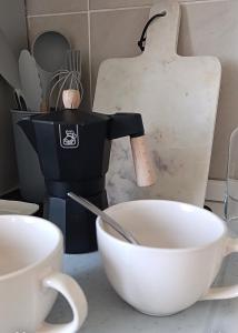 a coffee pot sitting on a counter next to a bowl at Kasakiwi Apartment in Vicenza