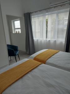 a hotel room with two beds and a window at Sunset Dunes in Cape Town