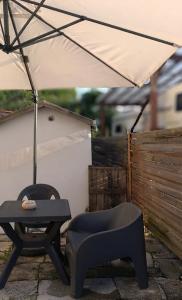 a table and a chair with an umbrella and a chair sidx sidx at Kasakiwi Apartment in Vicenza