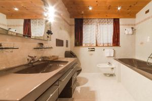 a bathroom with a sink and a toilet at Residence Chalet Pinis in Corvara in Badia +53 photos