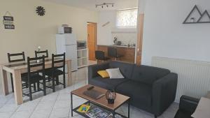 a living room with a couch and a table and a kitchen at Les Gites D'Angres in Angres