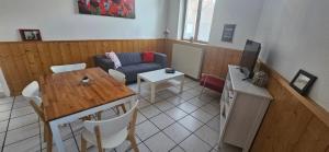 a living room with a table and a couch at Les Gites D'Angres in Angres