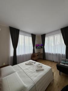 a bedroom with a large white bed and a couch at Villa Seli in Dogliani