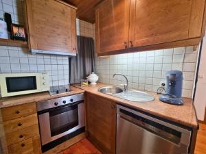 a small kitchen with a sink and a microwave at Apartamento-Estudio in Osséja