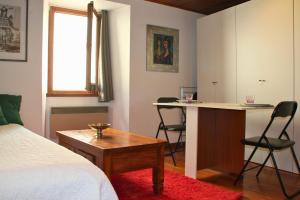 a bedroom with a bed and a desk with chairs at Apartamento-Estudio in Osséja