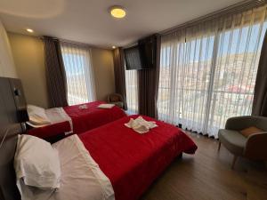 a hotel room with two beds and a large window at Hotel San Miguel Cusco in Cusco