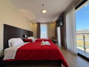 a bedroom with two beds and a large window at Hotel San Miguel Cusco in Cusco +4 photos
