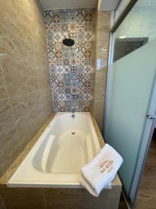 a bath tub with a towel sitting next to a shower at Hotel San Miguel Cusco in Cusco