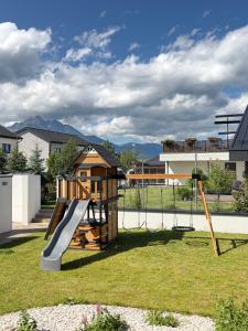 a playground with a slide in a yard at Vila Vento in Veľký Slavkov