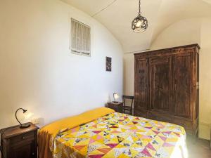 a bedroom with a bed with a colorful quilt on it at Apartment Risorgimento Apartment by Interhome in Cipressa