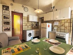 a kitchen with a green table with plates on it at Apartment Risorgimento Apartment by Interhome in Cipressa