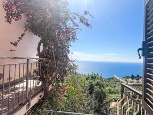a balcony with flowers and the ocean in the background at Apartment Risorgimento Apartment by Interhome in Cipressa