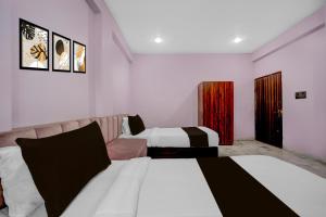 a hotel room with two beds and a couch at Hotel O G9 in Indore