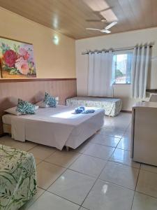 a large bedroom with two beds and a couch at Pousada Duas Praias in Guarapari +57 photos