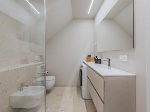 a white bathroom with a sink and a toilet at Apartment La Spada by Interhome in Ossana