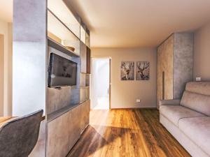 a living room with a couch and a television at Apartment La Spada by Interhome in Ossana +13 photos