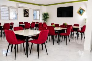 Ein Konferenzraum mit Tischen, roten Stühlen und einem Flachbildfernseher in der Unterkunft Breath Hôtel in Île Vitré