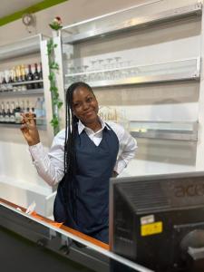 Eine Frau steht hinter einem Tresen in einem Supermarkt in der Unterkunft Breath Hôtel in Île Vitré
