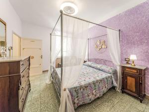 a bedroom with a canopy bed and purple walls at Apartment Nido nel centro by Interhome in Camaiore