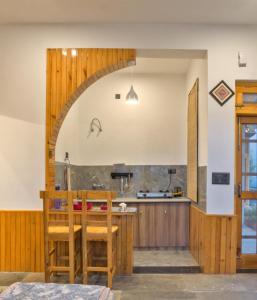 a kitchen with an archway and a table and chairs at Pine Grey Castle in Almora