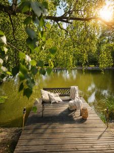 a bench sitting on a dock next to a lake at Glamping Cesty bez kompasu in Horní Jiřetín