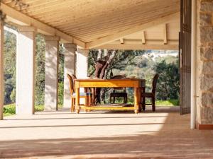 a wooden table and chairs on a porch at Villa S'Olioni by Interhome in Loceri