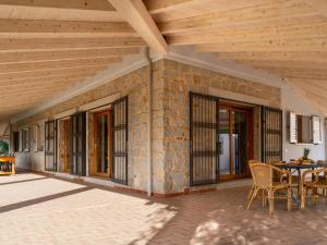 a patio with a table and chairs and a wooden ceiling at Villa S'Olioni by Interhome in Loceri +29 photos