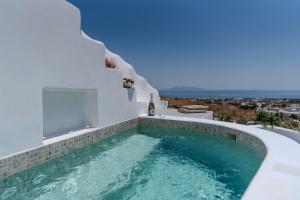 a swimming pool in a villa with blue water at EG Cave Houses in Éxo Goniá