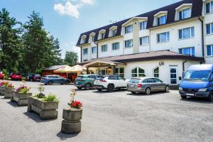 a large building with cars parked in a parking lot at RS Hotel in Rimavská Sobota