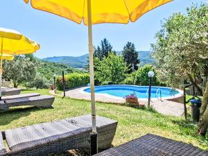 a yellow umbrella sitting on a table next to a pool at Holiday Home Luce by Interhome in Dicomano