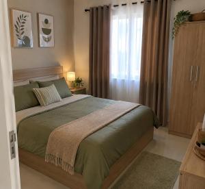 a bedroom with a large bed and a window at Darson Bahau Villa 3 in Kuala Pilah