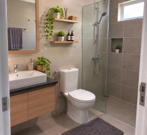 a bathroom with a toilet and a sink and a shower at Darson Bahau Villa 3 in Kuala Pilah