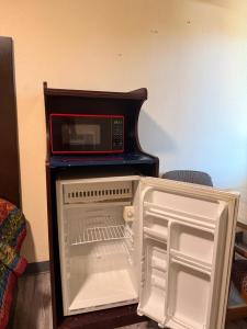 a microwave oven sitting on top of an open refrigerator at Golden Knight Motel in Gresham