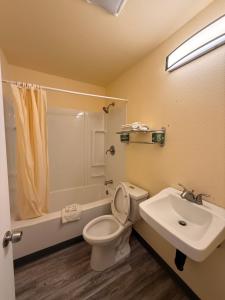 a bathroom with a toilet and a sink at Golden Knight Motel in Gresham