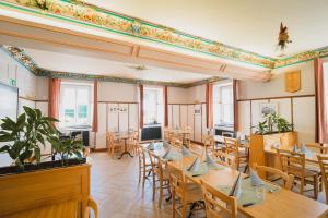a restaurant with wooden tables and chairs and windows at La Caquerelle in Col des Rangiers