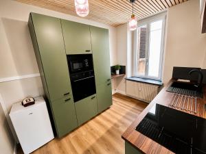 a kitchen with a green cabinet with a microwave at vaste appartement rénové avec terrasse in Morteau