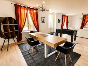 a living room with a table and a piano at vaste appartement rénové avec terrasse in Morteau