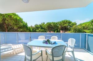 een terras met een tafel en stoelen op een balkon bij Residence Ca'Tullio in Bibione