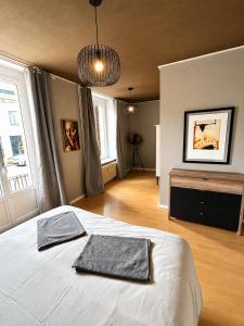 a bedroom with a bed with two towels on it at vaste appartement rénové avec terrasse in Morteau