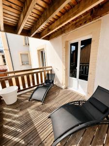 two chairs on a wooden deck with a balcony at vaste appartement rénové avec terrasse in Morteau