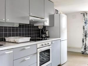 a kitchen with white cabinets and a stove top oven at Apartment Odal by Interhome in Halmstad