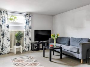 a living room with a couch and a tv at Apartment Odal by Interhome in Halmstad