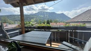 a table on a balcony with a view of a mountain at Gästehaus Zoller - Rettenberg im Allgäu in Rettenberg
