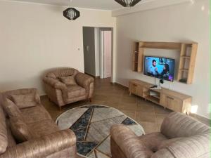 a living room with couches and a flat screen tv at Aparts 3 F3 BEJAIA VACANCE in Bejaïa