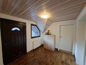 a hallway with a black door and a wooden ceiling at Zavetišče v Gozdu in Križe