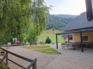 a picnic area with picnic tables and a building at Zavetišče v Gozdu in Križe